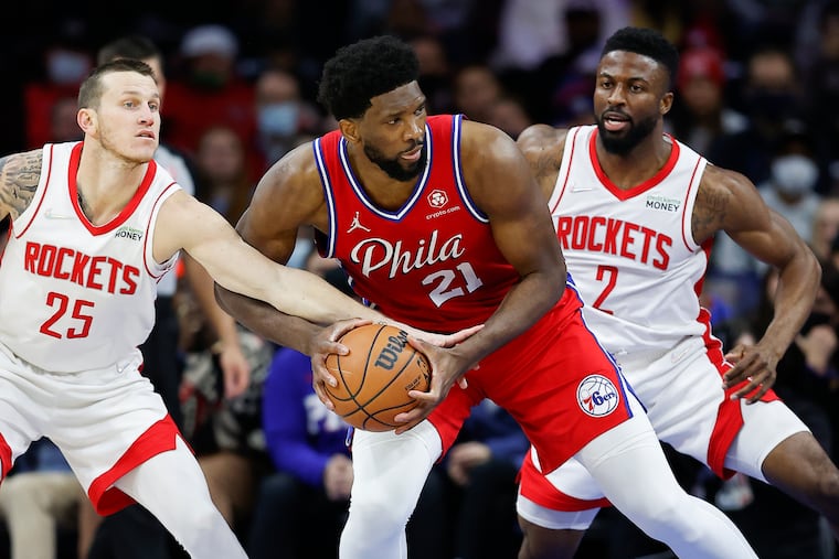 Sixers center Joel Embiid maneuvers between Houston's Garrison Mathews (left) and David Nwaba.