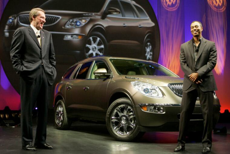 In happier, healthier times, GM chief Rick Wagoner shares an expensive laugh with Tiger Woods at the 2006 L.A. auto show, where the '08 Enclave was introduced.