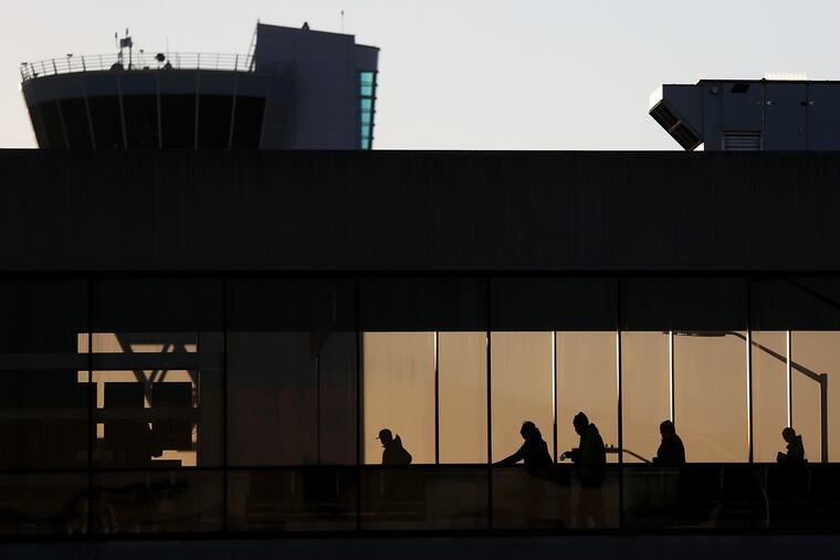 Travelers walk across a catwalk at Philadelphia International Airport. Airlines continuously review customer demand and make adjustments to the schedule, a United spokesperson said.