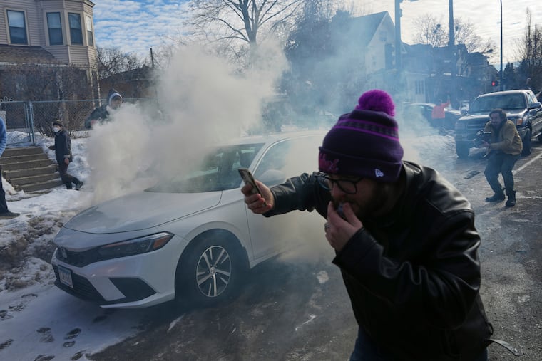 Protesters try to avoid tear gas dispersed by federal agents, Monday, Jan. 12, 2026 in Minneapolis.