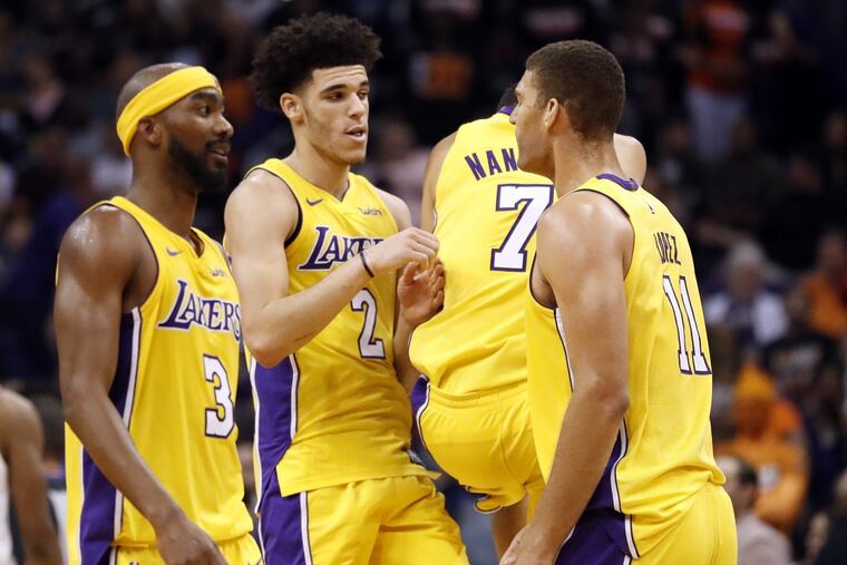 Los Angeles Lakers guard Lonzo Ball (2) and forward Larry Nance Jr. (7) celebrate during the second half of an NBA basketball game against the Phoenix Suns as guard Corey Brewer (3) and center Brook Lopez (11) watch, Friday, Oct. 20, 2017, in Phoenix. (AP Photo/Matt York)