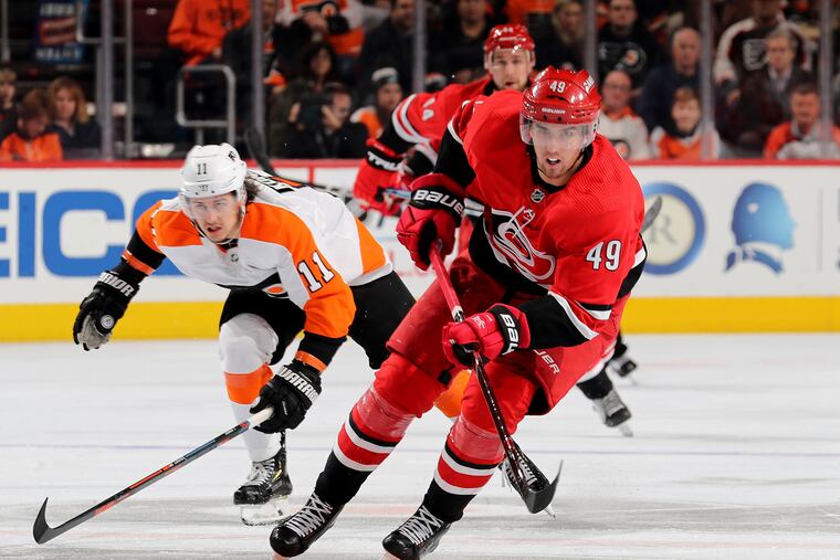 The Hurricanes' Victor Rask (49) takes the puck as the Flyers' Travis Konecny (11) defends.