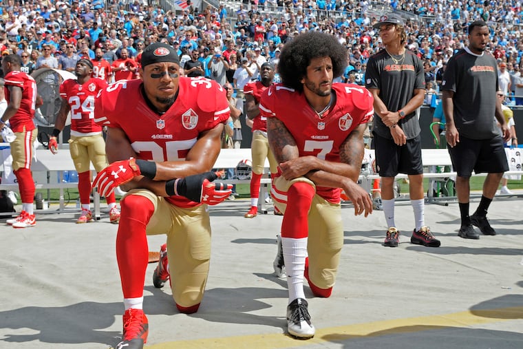 San Francisco 49ers' Colin Kaepernick (7) and Eric Reid kneeling during the national anthem before an NFL football game against the Carolina Panthers in Charlotte, N.C., on Sept. 18, 2016.