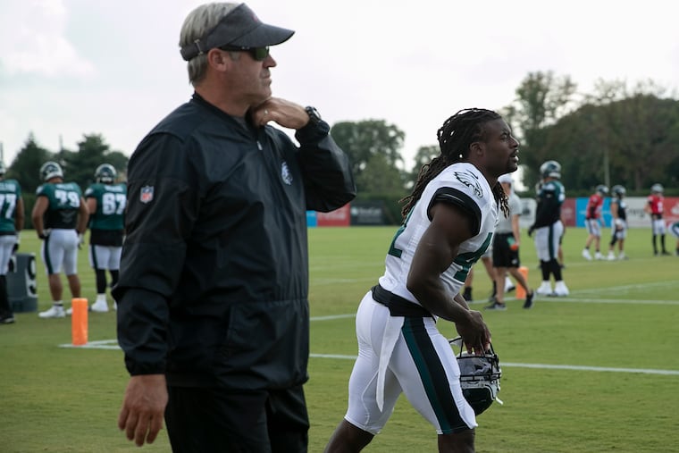 Eagles safety Johnathan Cyprien, center, walks out towards the field next to head coach Doug Pederson, left, before the start of training camp at the NovaCare Complex in South Philadelphia on Saturday, Aug. 03, 2019