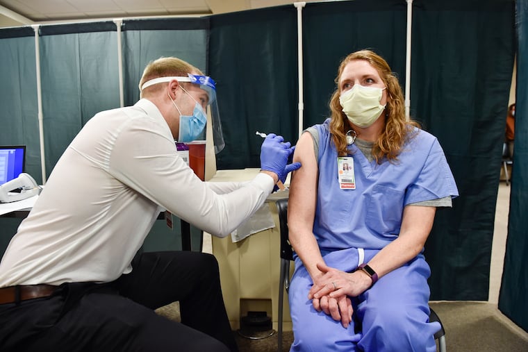 Julie Petre, an ICU pharmacist, receives the Pfizer COVID-19 vaccination at St. Peter's Health in Helena, Mont., in December. Medical providers and Montana residents with compromised immune systems are challenging the only law in the U.S. that prevents state employers from mandating workers get vaccinated.