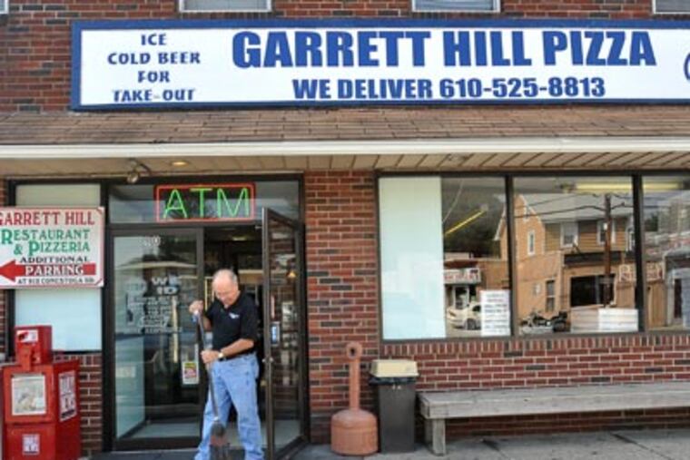 Joe Marchesani, owner of Garrett Hill pizza, sweeps clean the entrance to his restaurant before opening. ( Sharon Gekoski-Kimmel / StaffPhotographer )