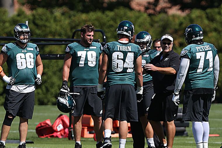 Eagles offensive linemen gather during practice. (David Maialetti/Staff Photographer)