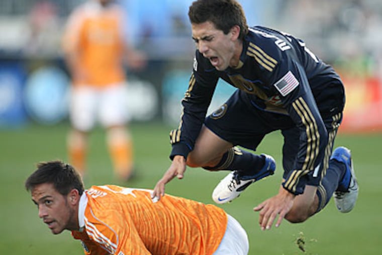 Michael Farfan grimaces after being upended by Houston's Danny Cruz during the first half. (Steven M. Falk/Staff Photographer)