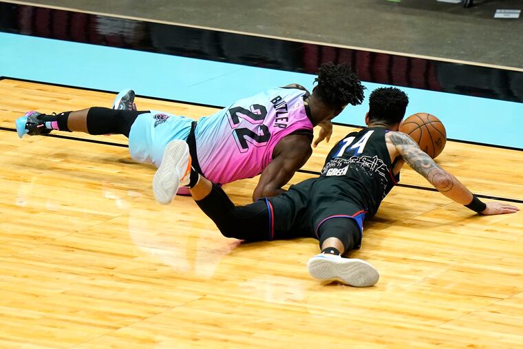 Heat forward Jimmy Butler (left) and 76ers forward Danny Green go for a loose ball.