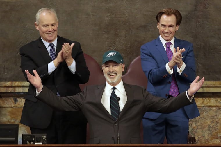 Democratic Gov. Tom Wolf puts on a Philadelphia Eagles hat to celebrate their Super Bowl win before he gives his budget address at the state Capitol in Harrisburg, Pa., on Tuesday, Feb. 6, 2018. (AP Photo/Chris Knight)