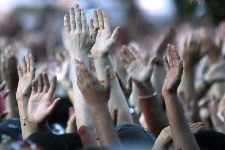 Fans cheer as J. Cole takes to the Liberty stage to perform during the Budweiser Made in America Festival, on the Ben Franklin Parkway, in Philadelphia on August 30, 2014.