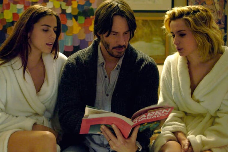 Keanu Reeves stars as Evan (center), with Lorenza Izzo as Genesis (left) and Ana De Armas as Bel. (Photo credit: Lionsgate Premiere)