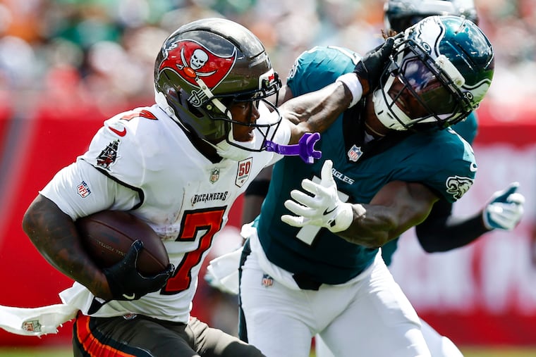 Eagles cornerback Kelee Ringo absorbs a stiff-arm from Buccaneers running back Bucky Irving in the first quarter Sunday.