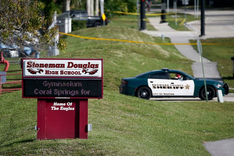 In this Feb. 15, 2018 photo, law enforcement officers blocked off the entrance to Marjory Stoneman Douglas High School, in Parkland, Fla., after a deadly shooting at the school.
