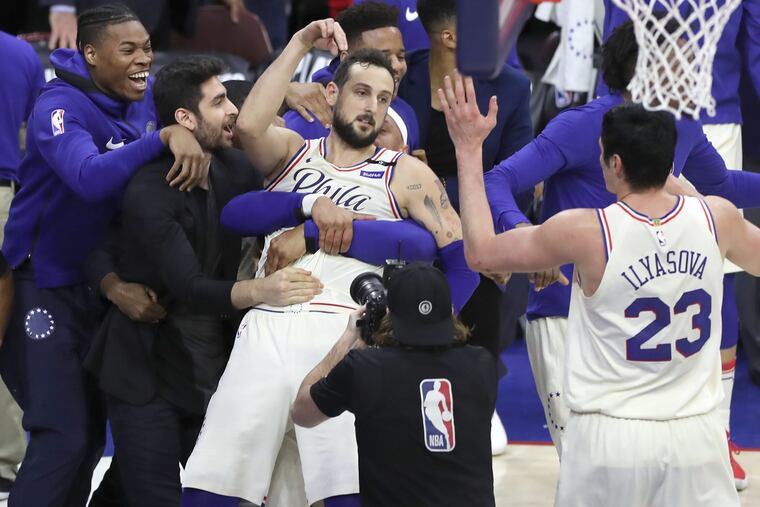 Marco Belinelli is swarmed by teammates after hitting a buzzer-beating two-pointer at the end of regulation of Game 3 on Saturday.