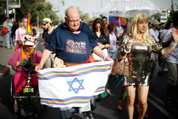 Participants hold flags during the annual Gay Pride parade in Jerusalem, Thursday, June 6, 2019. Thousands of people are marching through the streets of Jerusalem in the city's annual gay pride parade, a festival that exposes deep divisions between Israel's secular and Jewish ultra-Orthodox camps. (AP Photo/Ariel Schalit)