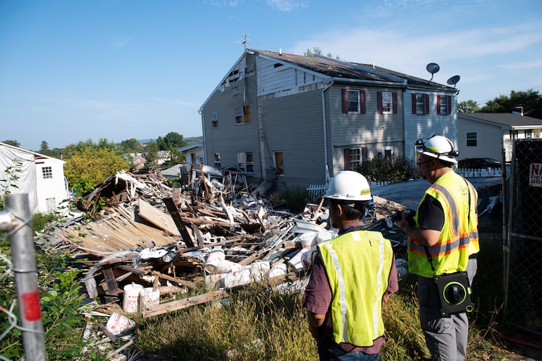 Members of the team sent out to investigate the site of a home explosion that occurred in May stand at the scene on Monday in Pottstown.