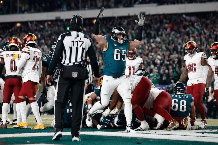 Eagles tackle Lane Johnson signals a touchdown after a Tush Push score by quarterback Jalen Hurts against the Commanders.