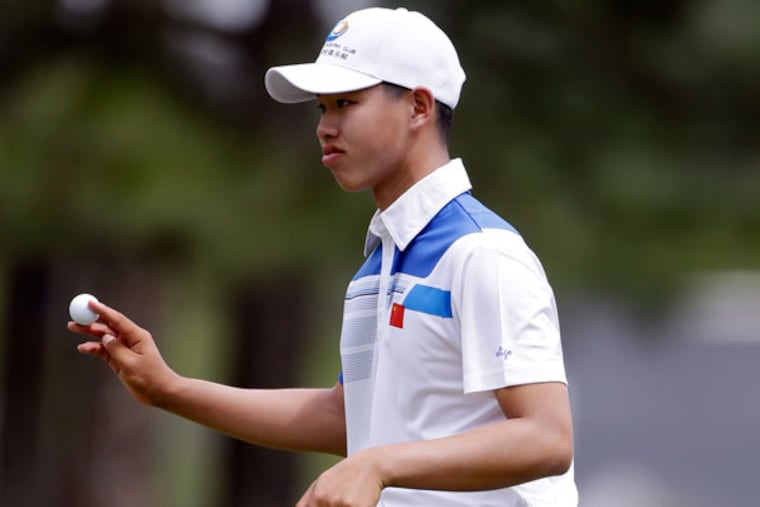 Amateur Guan Tianlang holds up his ball after putting the eighth green during the first round of the Masters golf tournament Thursday, April 11, 2013, in Augusta, Ga. (David Goldman/AP)