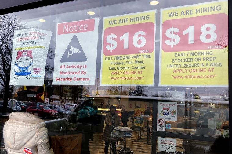 Hiring signs are displayed at a grocery store in Arlington Heights, Ill., earlier this month.