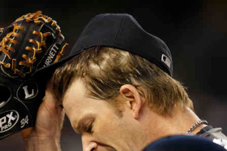 Yanks pitcher A.J. Burnett reacts after his error allows run to score.