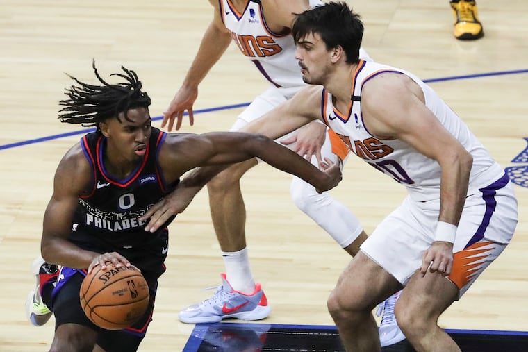 Sixers guard Tyrese Maxey (0) drives past Phoenix Suns forward/center Dario Šarić during an April game at the Wells Fargo Center.