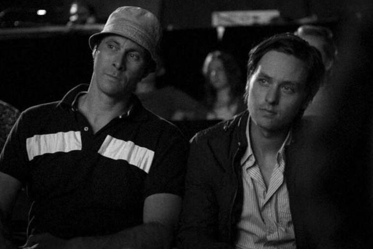 Marc Hosemann (left) as Matze and Tom Schilling as Niko Fischer watcha movie in "A Coffee in Berlin."