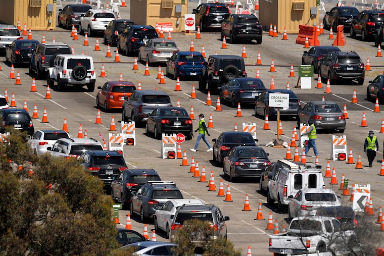 In this July 14, 2020 file photo, people wait in line for coronavirus testing at Dodger Stadium in Los Angeles. A vaccine could help end the pandemic, but those products haven't historically been profitable for drug companies. (AP Photo/Mark J. Terrill, File)