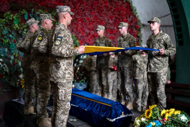 Servicemen pay respect at the coffin of Olga Simonova, 34, a Russian woman who was killed while fighting on Ukraine's side in the war with her native country.