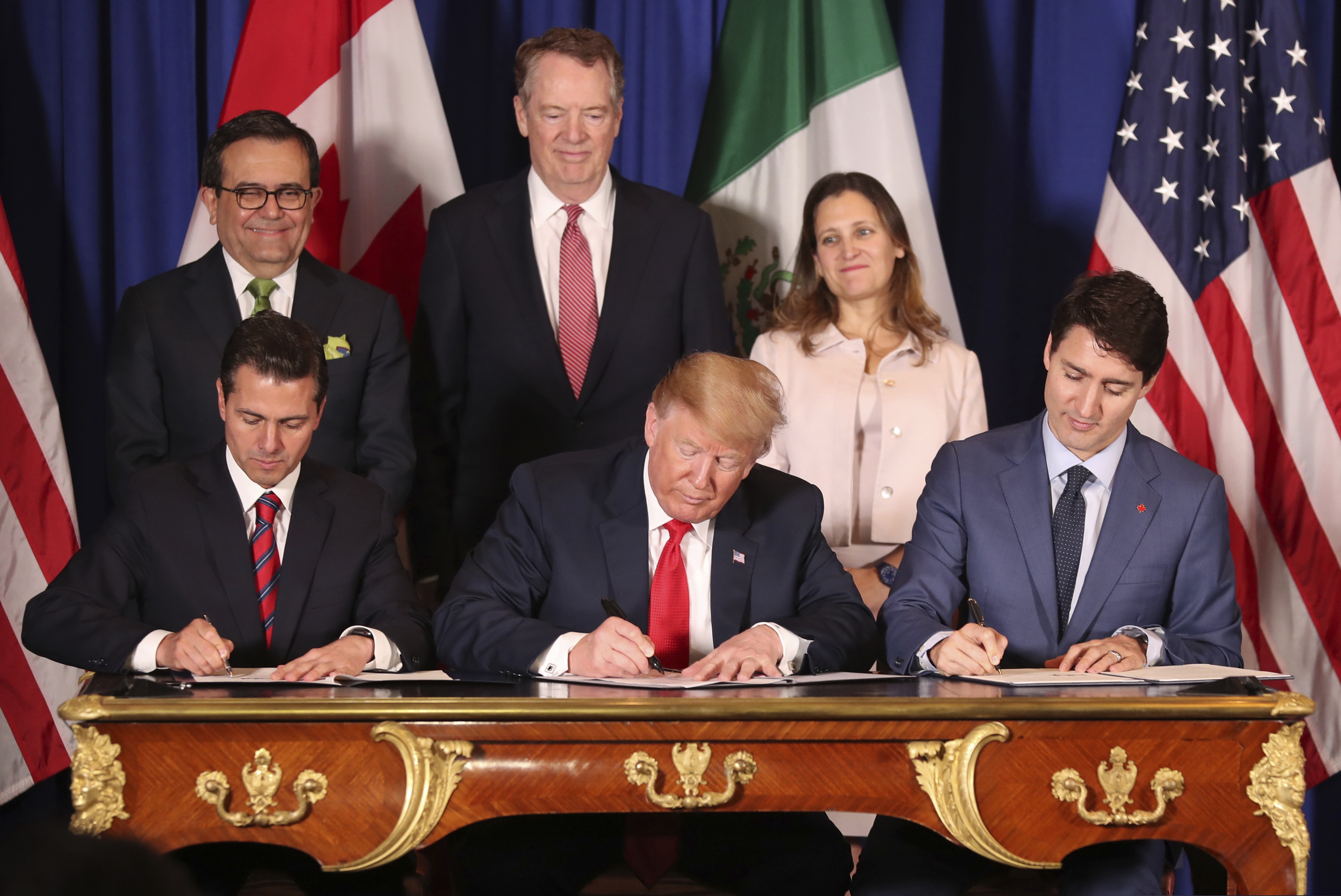 In this Nov. 30, 2018 file photo, President Donald Trump sits between Canada's Prime Minister Justin Trudeau (right) and Mexico's President Enrique Pena Nieto as they sign a new United States-Mexico-Canada Agreement that is replacing the NAFTA trade deal, during a ceremony at a hotel before the start of the G20 summit in Buenos Aires, Argentina.