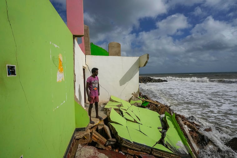 FILE - Dilrukshan Kumara looks at the ocean as he stands by the remains of his family's home in Iranawila, Sri Lanka, June 15, 2023. (AP Photo/Eranga Jayawardena, File)