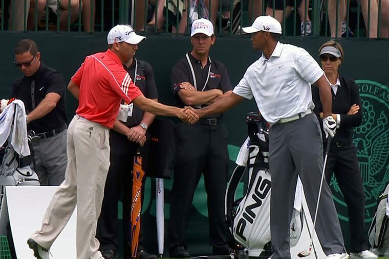 In this Monday, June 10, 2013 image taken from video and provided by The Golf Channel, Sergio Garcia, left, and Tiger Woods shake hands on the driving range during practice for the U.S. Open golf tournament at the Merion Golf Club in Ardmore, Pa. (AP Photo/Courtesy of the Golf Channel)