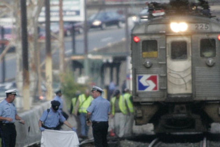 Police cover the body of a man struck by a SEPTA train in East Falls this morning. (Robert Moran / Inquirer)