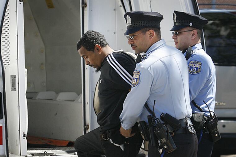 Philadelphia police put an alleged bank robber into a police van at Richmond and Allegheny Streets after using GPS technology to follow money stolen from a PNC Bank branch at 1600 Market St.