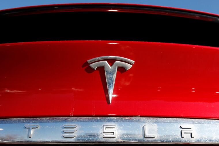 The Tesla company logo is shown at a Tesla dealership in Littleton, Colo., in 2020.