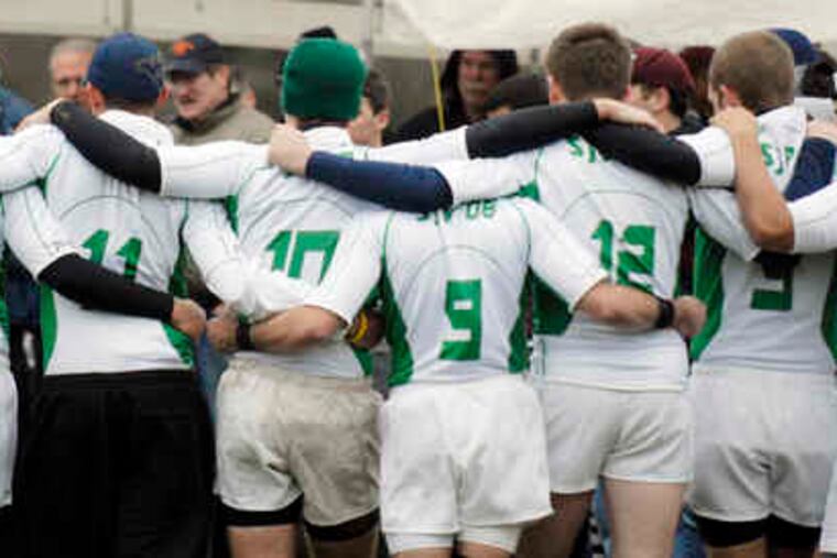 Huddled in prayer, members of the St. Joseph's Prep alumni rugby team 428 West begin their memorial fund-raiser in Fairmount Park.