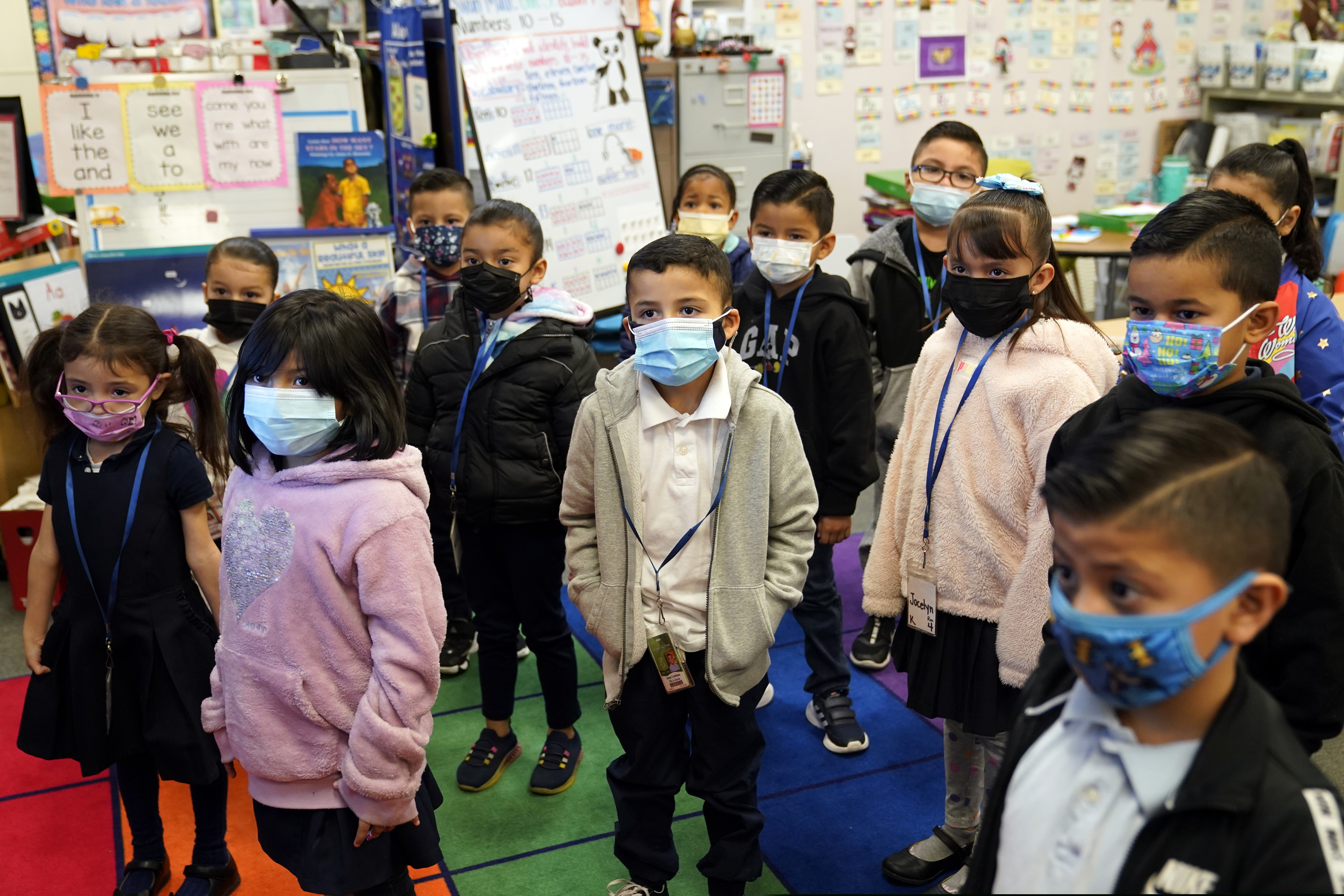 Kindergarteners wear masks while listening to their teacher amid the COVID-19 pandemic at Washington Elementary School Wednesday, Jan. 12, 2022, in Lynwood, Calif.