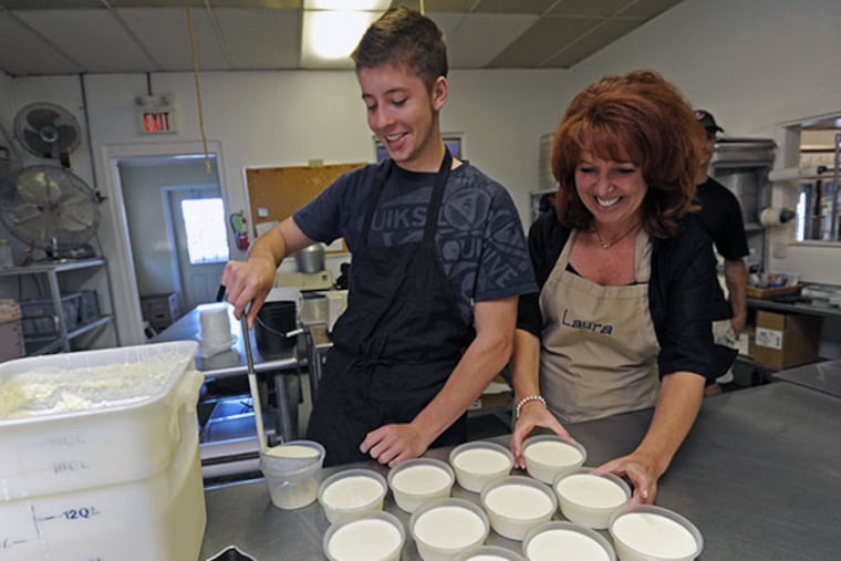At L.E. Roselli's in Medford, Leo Roselli's widow, Laura Roselli, with their two sons, Matt Roselli, 16, and Leo Roselli, 14, on Sept. 19, 2013. Here, Matt pours cream sauce in the kitchen with Laura at his side. ( APRIL SAUL / Staff )