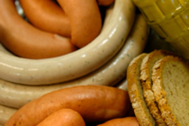Marcus Rieker (above) removes sausage from smoker; at left are some of the food shop's wursts.