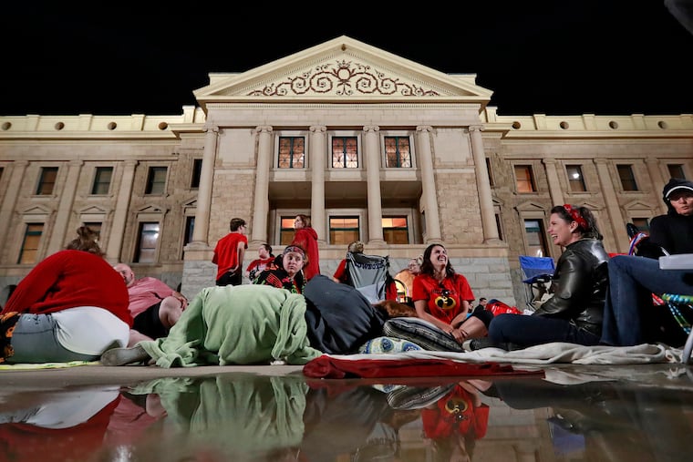 Teachers camp out for the night as the Arizona legislature debates a budget negotiated by majority Republicans and GOP Gov. Doug Ducey at the Capitol in Phoenix on May 3, 2018. Attempts that year to boost school funding by raising taxes on the wealthy stalled, but the state voted in such a tax in November.