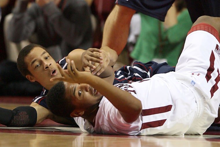 Temple's Khalif Wyatt and Penn's Cameron Gunter watch the loose ball during a 2011 game.