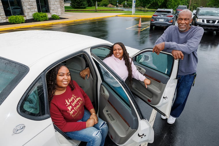 Shellman Washington 3rd, right, stands beside his 2003 Chevrolet Impala, which he used to drive his twin daughters back and forth to their classes at Neumann University. Daughters from left are twin sisters, Da’Veigh and Davay Washington, 22.
