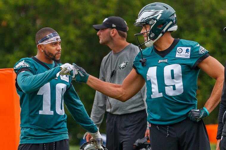 Two of the Eagles' new wide receiver additions — DeSean Jackson, left, and J.J. Arcega-Whiteside, right — exchange a fist bump during one of the team's spring workouts.