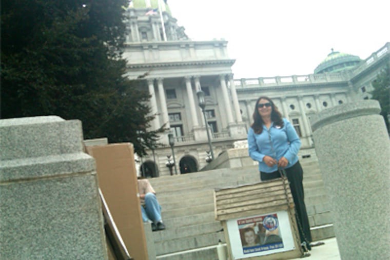 Tamira Ci Thayne says she will stay at the doghouse she brought to the Capitol until legislation banning round-the-clock chaining is passed, or until she thinks she's done all she can do. (Amy Worden / Staff)
