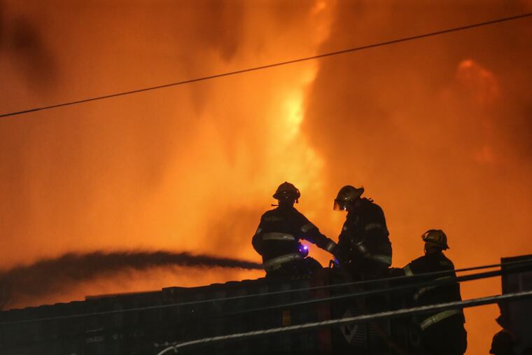 Firefighters battle a three alarm junkyard fire at Tulip and Somerset streets in Kensington, Tuesday, July 10, 2018. STEVEN M. FALK / Staff Photographer