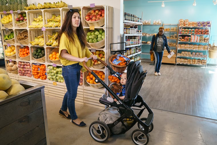 Vera Rosen shops with son Maksen Kenzou at the newly opened Kensington Community Food Co-op in Philadelphia on April 24.