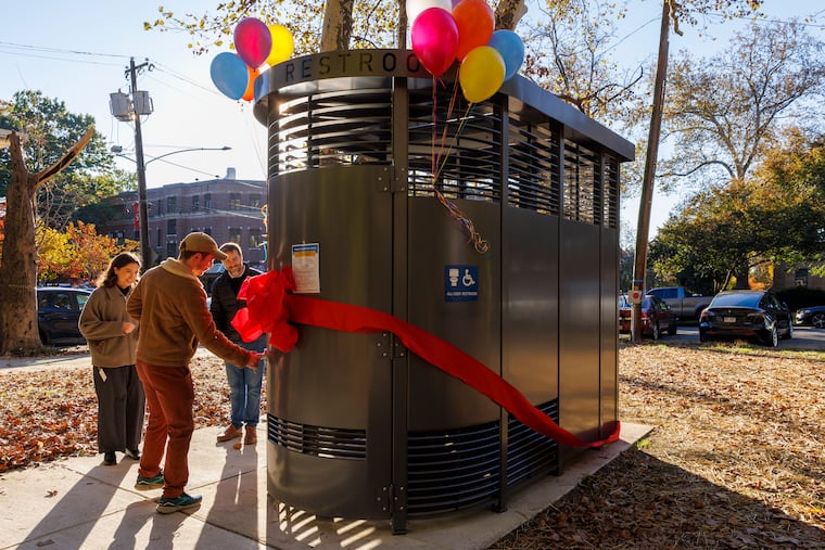 John Schaeffer winner of the lottery to be first person to use new Philly Phlush, Clark Park, W. Philadelphia, Monday, October 27, 2025. At right is Jonathan Aviles, SUPHR's Environmental Services team.