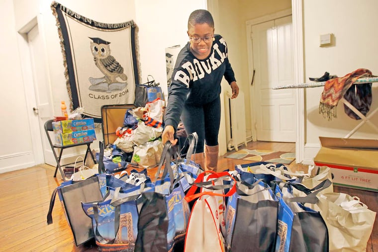 Temple junior Lorae Bonamy, 21, prepares care packages (she calls them "love packages") for homeless people in a friend's West Philadelphia home on Sunday, December 21, 2014. ( YONG KIM / Staff Photographer )