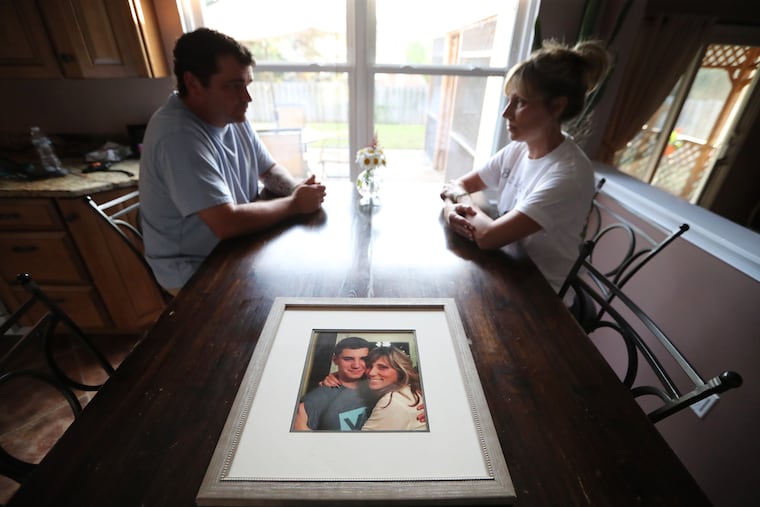 Anthony and Bonnie Finocchiaro, parents of Dean Finocchiaro, sits at their kitchen table, where a framed photograph of Bonnie and Dean embrace on the anniversary of the murders of four young men in Bucks County July of 2017.