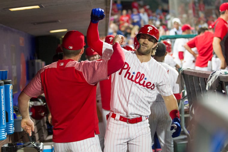 Bryce Harper, right, and Rhys Hoskins of the Phillies celebrate in the dugout after Harper's 3-run home run against the Padres in the 6th inning at Citizens Bank Park on Aug. 16, 2019.